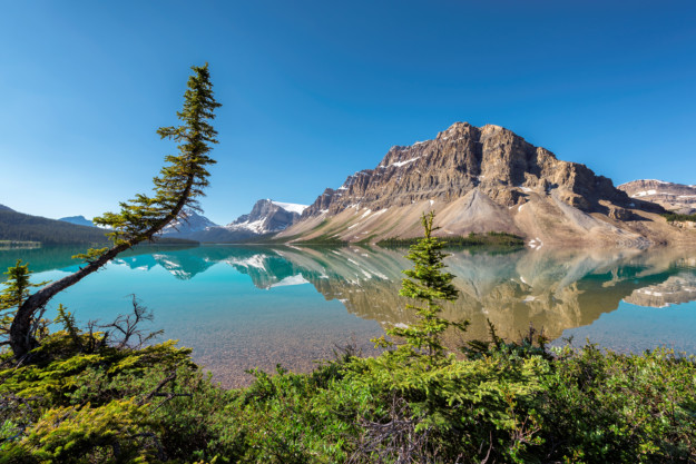 Rocky mountains reflected in still lake, Canadian Rockies of Banff NP, Canada.