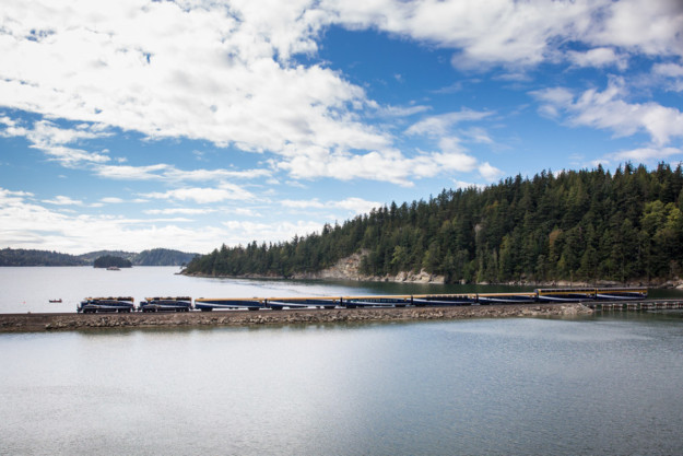 train crosses a narrow stone bridge in a vast lake