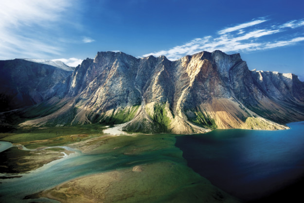 a oddly shpaed mountains rises from a deep blue expanse of water