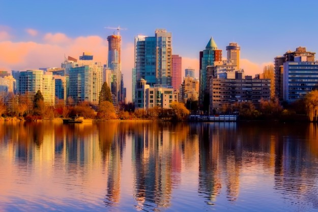 the vancouver cityscape reflected in the shimmering water in the foreground