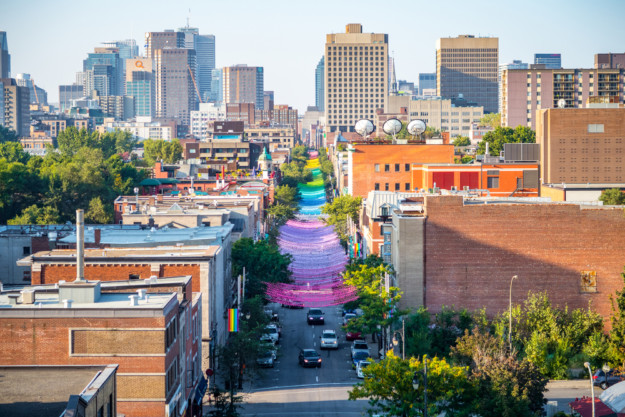 a view down a Montreal street with rainbow coloured lights strung up
