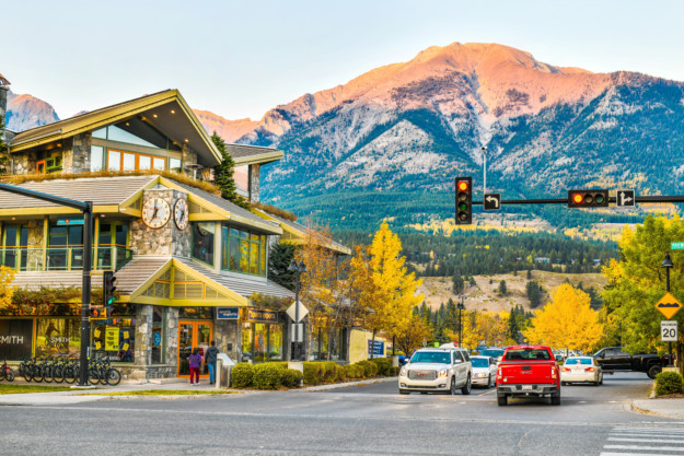 a street in Canmore with a sun kissed mountain in the background
