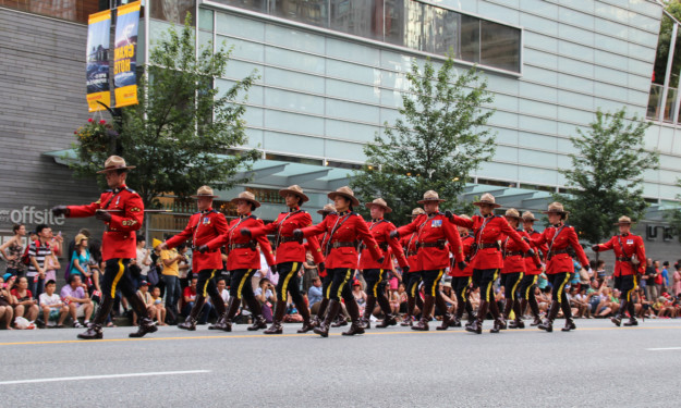 Canadian Mounties march down the street in their red and black uniforms