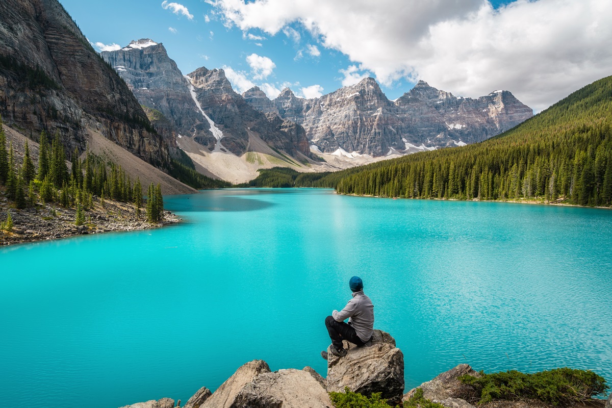 A hiker looks over Moraine Lake in Canada