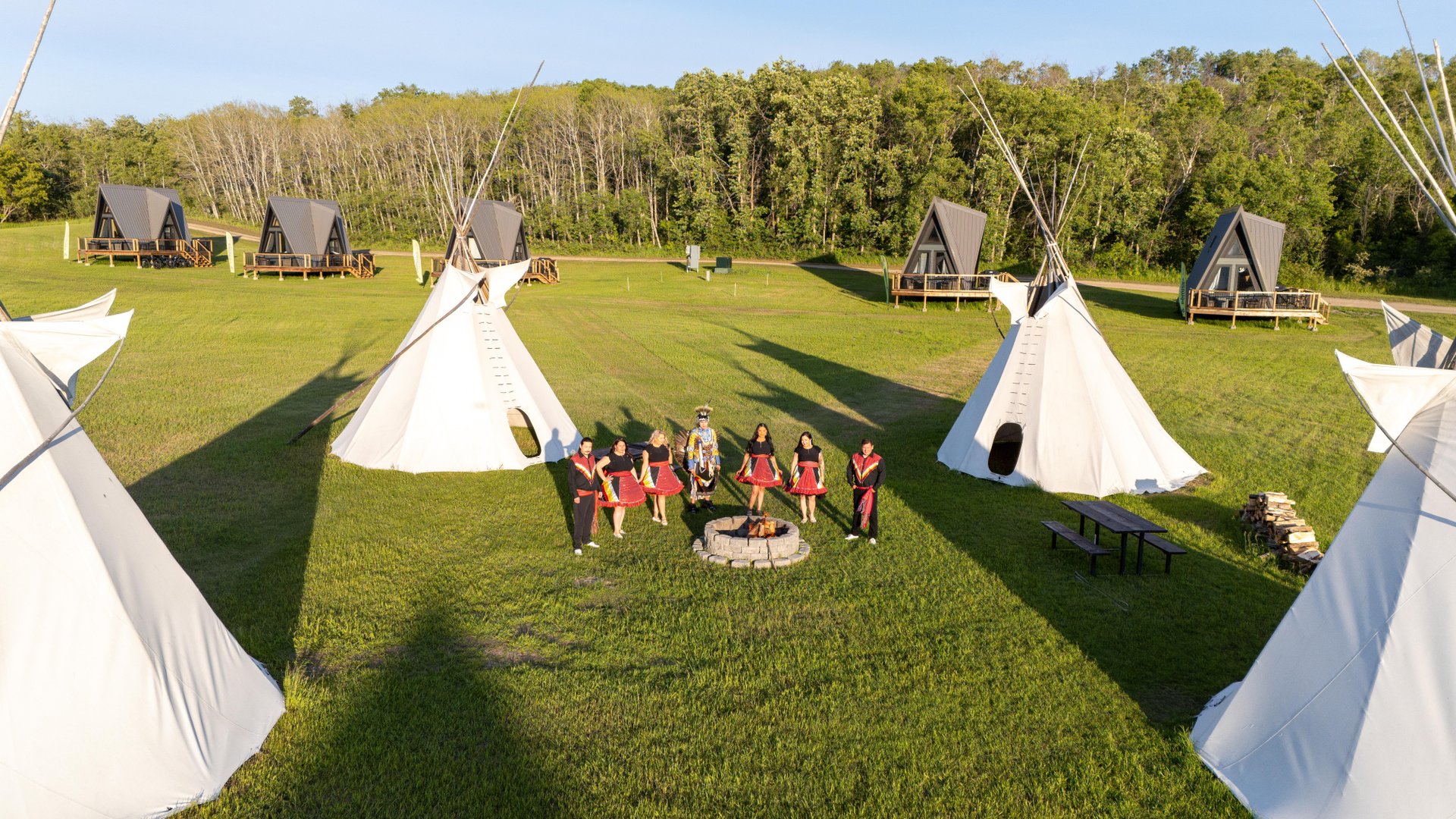 Indigenous dancers next to tipis at the Fort Carlton Provincial Historic Park in Saskatchewan