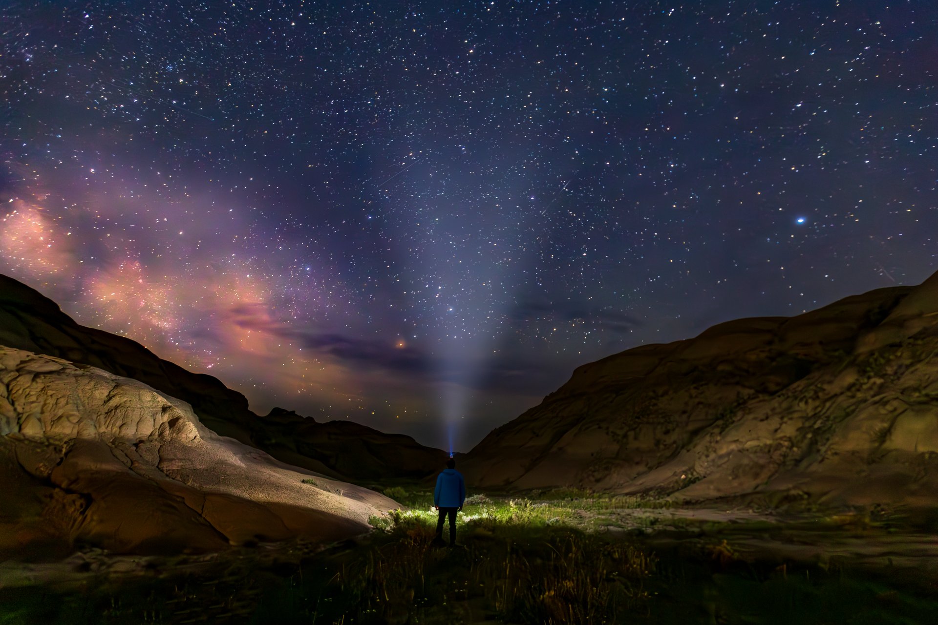 A man is looking at a starry night sky in Grasslands National Park in Saskatchewan