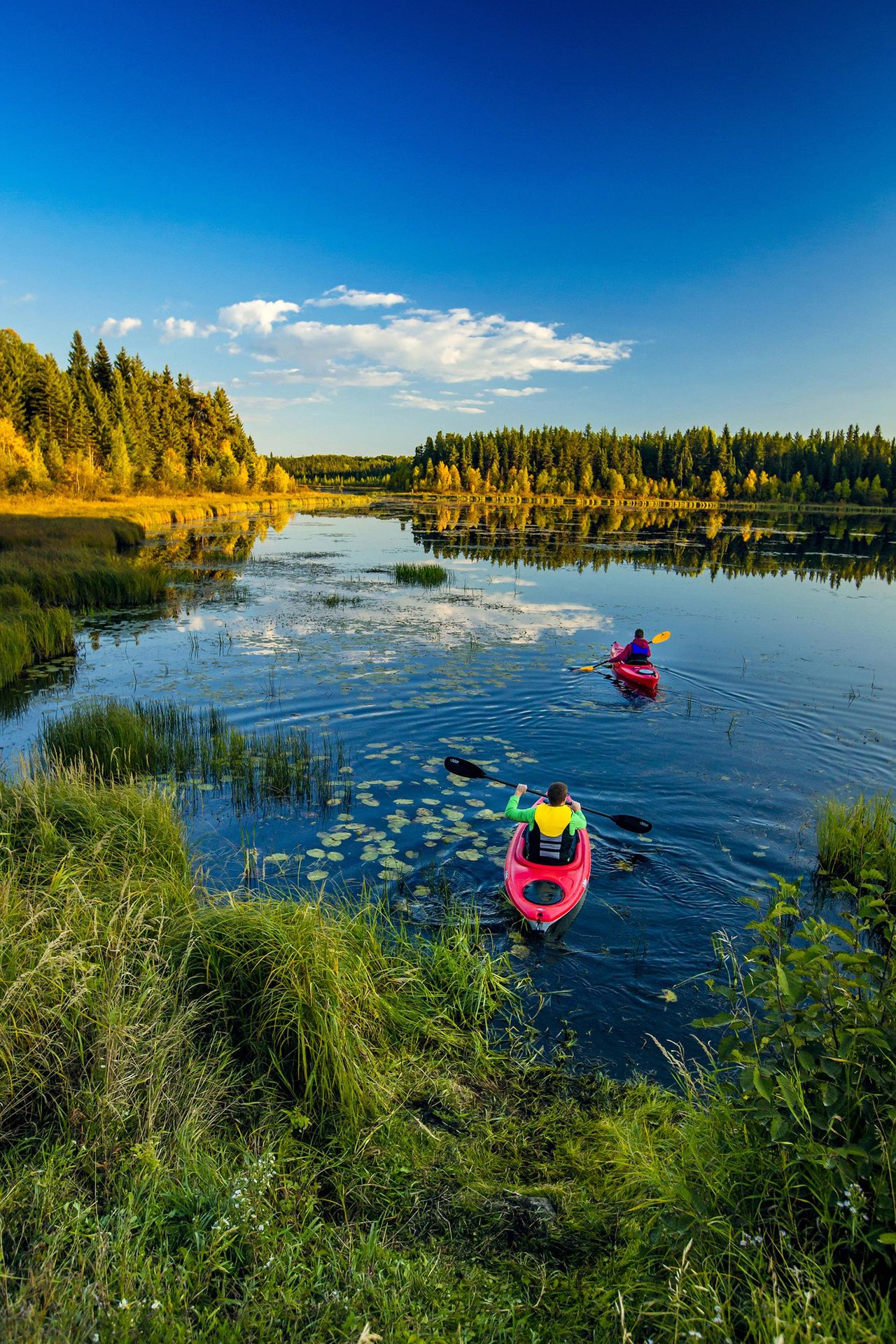 Two people kayaking in a lake in Prince Albert National Park in Saskatchewan